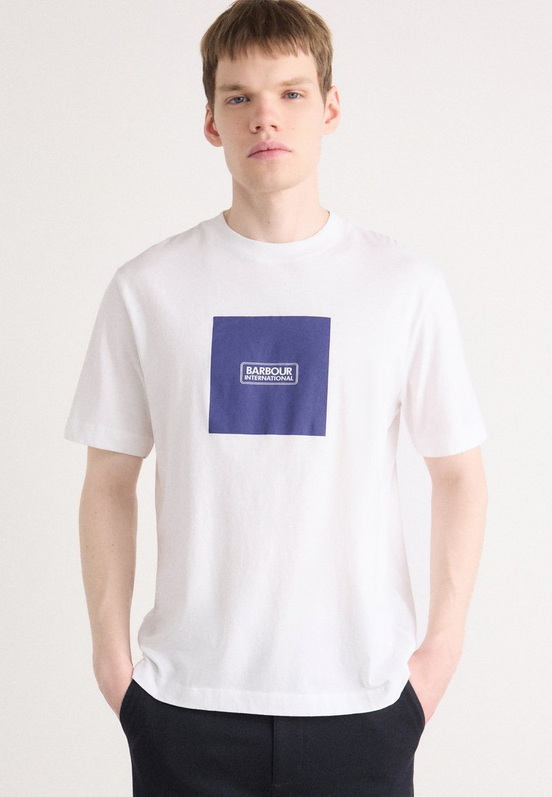 Bílý bavlněný tričko s modrým čtvercem a logem "BARBOUR INTERNATIONAL". Kulatý výstřih, krátké rukávy, volný střih.