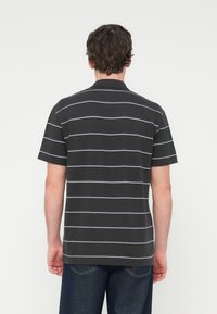 Πόλο μπλούζα με κοντό μανίκι σε σκούρο γκρι χρώμα με λευκές και ανοιχτομπλε οριζόντιες ρίγες, που διαθέτει κλασικό γιακά και άνετη εφαρμογή.