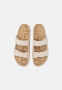Sandali color beige chiaro con due cinturini regolabili, realizzati in morbida pelle scamosciata, dotati di una soletta sagomata e particolari a logo impresso sulle solette.
