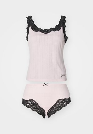 Top in tessuto leggero rosa chiaro con rifiniture in pizzo e spalline regolabili, abbinato a mutandine boy short coordinate, con dettagli in pizzo e un fiocco.