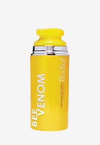 Gelbes zylindrisches Gefäß mit glänzender Oberfläche, silbernen Akzenten und einem sicheren Drehverschluss, beschriftet mit "Bienenvenen-Reinigungsbalsam."