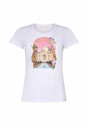 T-shirt blanc avec le texte « EXPLORE » au-dessus du Taj Mahal, entouré de plantes tropicales, fleurs, un tigre et un ananas sur un fond rose.