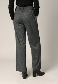 Grijze steentijgerbroeken van textuurstof met een elastische tailleband, met een ontspannen pasvorm en een zakdetail aan de achterkant.