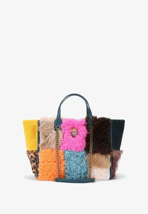 Patchwork handtas met verschillende texturen in geel, roze, oranje, blauw, bruin en zwart, met een kettinghandvat en decoratieve accenten.