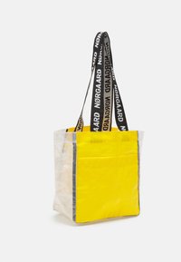 Borsa tote con fronte trasparente, retro giallo brillante e manici neri con il testo "Nørgaard". Forma rettangolare, superficie liscia.