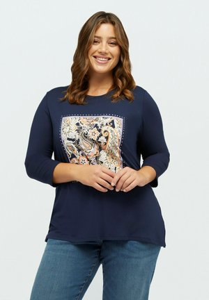 Navy blue shirt with 3/4 sleeves and a paisley-patterned front accent framed by embellishments. Soft fabric, relaxed fit.