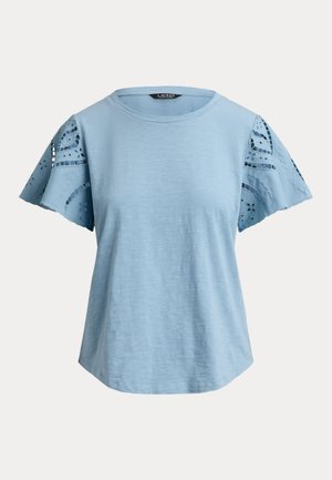 Ανοιχτό μπλε κοντομάνικο τοπ με στρογγυλή λαιμόκοψη και κεντημένα, δαντελωτά μανίκια με ανοίγματα, παρουσιασμένο σε απλό φόντο.