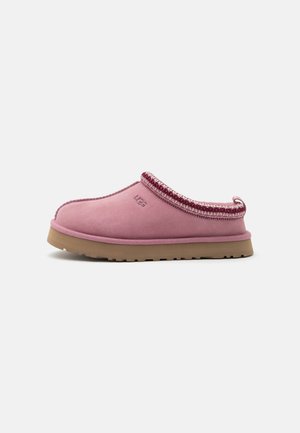 Pantofole rosa slip-on con suola beige e bordo decorato, con logo ricamato sul lato.