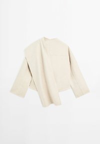 Veste beige texturée avec une coupe ample, dotée d'un seul panneau drapé sur une épaule et de manches larges, avec des coutures minimales et sans fermetures.