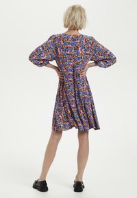 Robe à manches courtes à motifs floraux dans des teintes de bleu, d'orange et de rose, avec une coupe décontractée et une taille froncée, fabriquée en tissu léger.