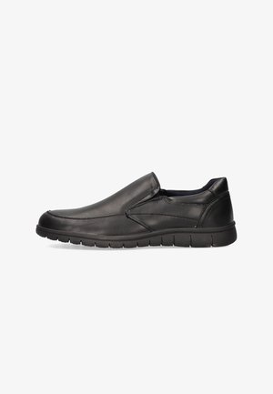 Zapato negro de piel deslizante con punta redondeada, superficie texturizada y suela de goma flexible, que muestra un diseño moderno y casual.