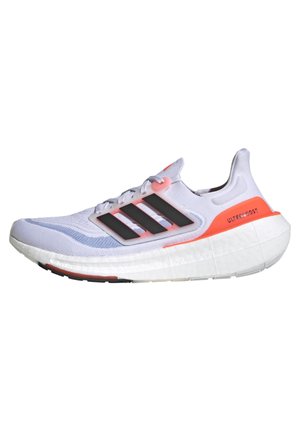 Chaussure de running Adidas Ultraboost blanche et orange avec logo trois bandes noir et semelle amortie vue de côté.