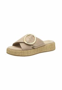 Sandales à plateforme beiges avec une large sangle, ornées d'un accent circulaire en or. La semelle est texturée avec un motif tissé.