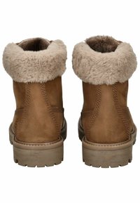 Braune Wildleder-Ankle-Boots mit einem beigen Kunstfellkragen und Gummisohlen. Steppdetails an den Seiten verleihen Textur und Struktur.