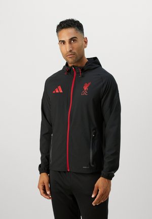 Black windbreaker jacket with red accents, featuring an L.F.C. logo, zip closure, two side pockets, and elastic cuffs. Lightweight fabric.