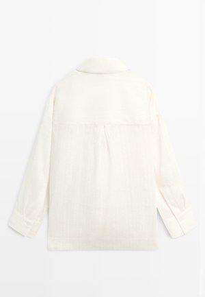 Chemise crème à manches longues avec col, poignets boutonnés et pli central dans le dos, présentée à plat sur fond blanc.