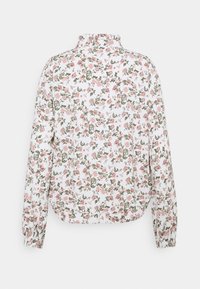 Blommönstrad jacka med vit bakgrund och rosa samt gröna blommor. Hög krage och elastiska ärmslut, tillverkad av lättviktsmaterial.