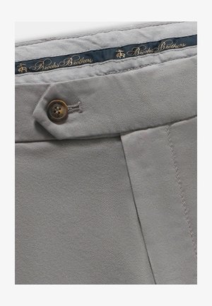 Pantalons en tissu coton gris avec une fermeture à bouton marron unique et une ceinture bleue portant l'inscription "Brooks Brothers" embossée en or.