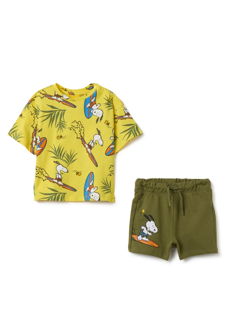 T-shirt gialla a maniche corte con stampa di una tavola da surf e palme, abbinata a pantaloni corti verde oliva con grafica di Snoopy e vita elastica.