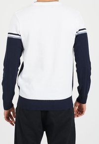 Biały sweter z mieszanki bawełny z granatowymi prążkowymi rękawami, z paskowanymi akcentami w kolorach szarym i granatowym na ramionach i mankietach.