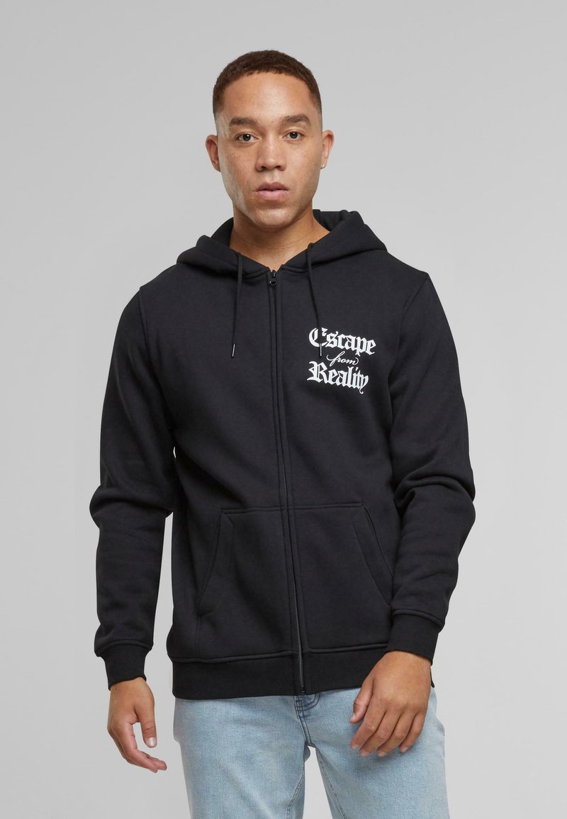 Sort zip-up hoodie med forlommer, snøre i huen og hvid tekstgrafik "Escape from Reality" på venstre bryst. Blød stofstruktur.