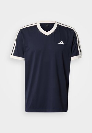 Tmavě modré sportovní tričko s výstřihem do V, bílými lemy na rukávech a dvěma bílými proužky podél ramen. Má malé bílé logo.