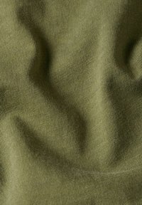 Tessuto di un verde oliva con texture a coste, che mostra lievi pieghe e grinze. Il materiale appare morbido e leggermente elastico.
