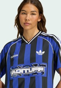 Dres Adidas s modrými a černými vertikálními pruhy, v-výstřihem a korálkovým logem "ADITUFF" na přední straně. Hladký, atletický materiál.