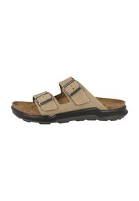 Sandalo scivoloso in suede beige con doppie cinghie regolabili, fibbie in metallo, suola in sughero e suola in gomma nera.