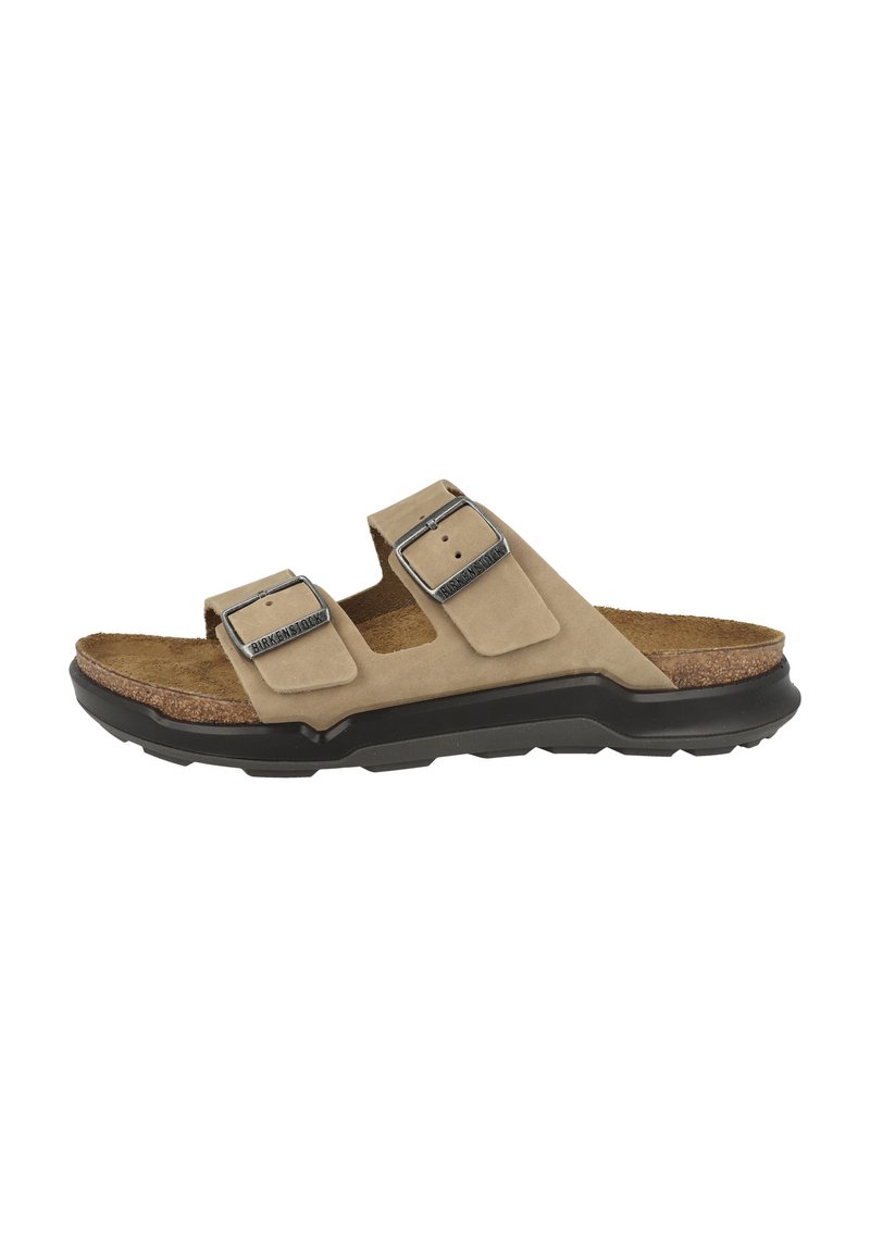 Sandalo scivoloso in suede beige con doppie cinghie regolabili, fibbie in metallo, suola in sughero e suola in gomma nera.