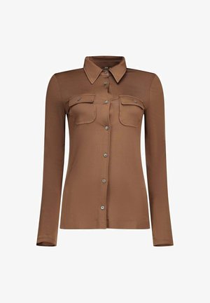 Chemise marron à manches longues avec boutons, col pointu et deux poches poitrine à rabat boutonnées, présentée sur fond blanc.