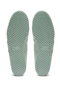 Světlé zelené podrážky tenisek s texturovaným gumovým povrchem a diamantovými vzory. Logo značky vyražené poblíž oblasti paty.