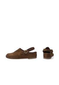 Brune ruskind slip-on sko med en bagside og cirkulær dekor. Glat overflade, afrundet tå og flad sål.