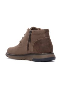 Botines de ante marrón con cremallera lateral, punta redonda, acabado texturizado y costuras en contraste, montados sobre una suela de goma flexible.