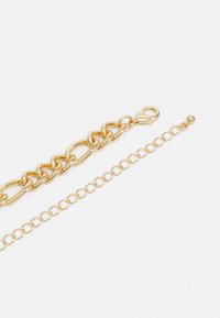Gold-tone bracelet featuring interlocking links, a lobster clasp, and an adjustable chain extension with a small bead detail.