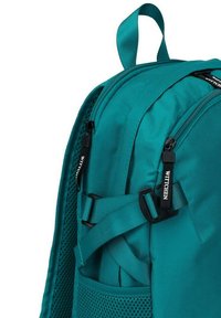 Mochila turquesa con una tela texturizada, doble cremallera con tiradores de marca y correas ajustables. Bolsillo de malla lateral para almacenamiento adicional.