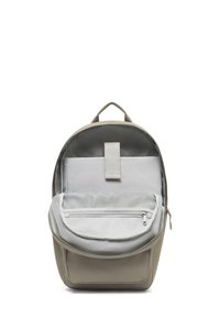 Rucsac bej cu o formă rotundă, având un interior gri, un buzunar cu fermoar și un compartiment din plasă. Material durabil, cu un mânere de sus.