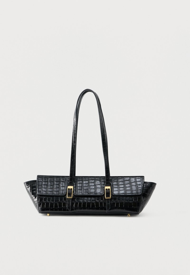 Μαύρη τσάντα χειρός με υφή κροκοδείλου, μακριές  λαβές και χρυσές πόρπες, τοποθετημένη σε απλό λευκό φόντο.
