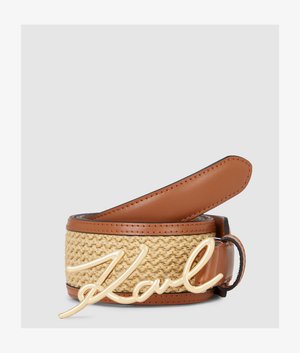 Hnědý kožený a tkaný pásek se zlatým lesklým cursivním přezkou ve tvaru "Karl", stočený na jednobarevném šedém pozadí.