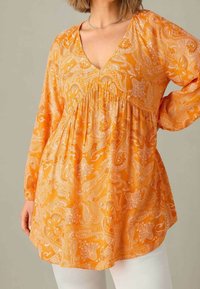 Blusa de color naranja con estampado paisley, de manga larga, escote en V profundo y detalle fruncido en la cintura, fabricada en tejido ligero.