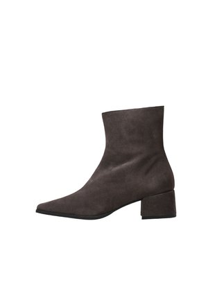 Bota de tobillo de ante marrón oscuro con punta afilada y tacón bajo de bloque, vista de lado sobre un fondo blanco.