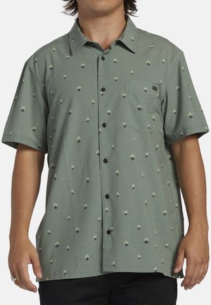 Short-sleeve green button-up shirt with black buttons, featuring a geometric pattern of small diamonds and triangles. Includes a chest pocket.
