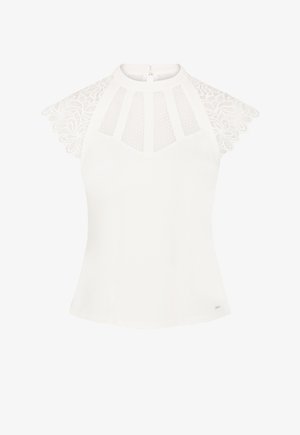 Blouse blanche avec des manches courtes en dentelle, dotée d'un col haut et d'un zip dans le dos. L'avant présente un design à panneaux avec des détails texturés.