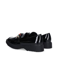 Zapatos de charol negro con suela gruesa, que presentan una hebilla dorada y un detalle de franjas verde-rojo-verde en la parte delantera.