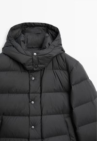 Schwarze Pufferjacke mit Kapuze, mit einem gesteppte Design, Druckknopfverschluss und glatter Textur. Keine zusätzlichen Muster oder Akzente.