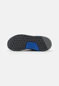 Sola de calçado Adidas, apresentando uma base de borracha preta com um padrão hexagonal texturizado, detalhes em azul, e uma secção intermediária cinza para maior aderência.