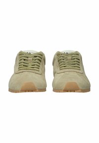 Pari beigejä mokkanahkaisia tennareita, joissa on vihreät nauhat ja kumipohjat, nähtynä edestä valkoisella taustalla.