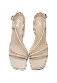 Beige-nahkaiset sandaalit, joissa on neliömäinen kärki, sileä nahkapinta, säädettävä nilkkavyö ja minimalistinen tyyli.