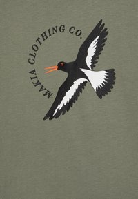 Green cotton t-shirt featuring a black and white bird graphic with bright orange beak and eye, surrounded by "MAKIA CLOTHING CO." text.