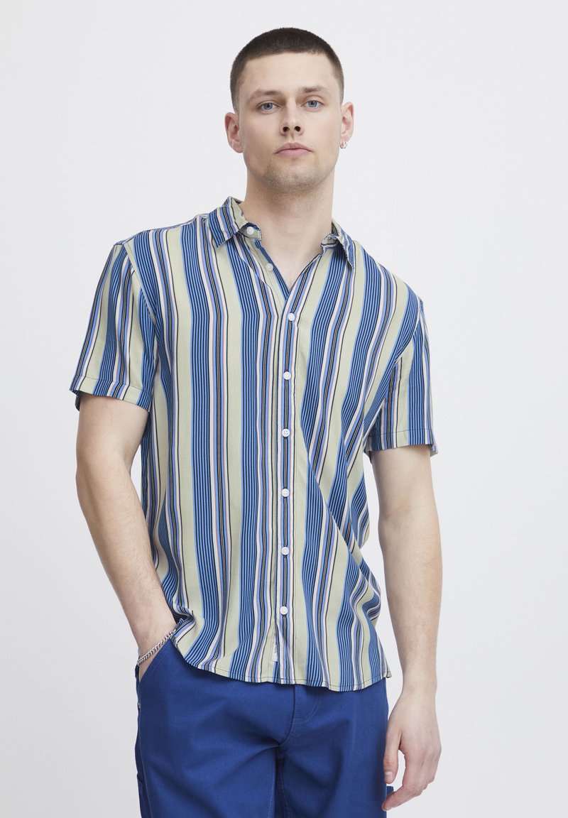 Camicia a maniche corte con bottoni, caratterizzata da righe verticali blu e verdi con sottili accenti rossi, realizzata in tessuto leggero e con una vestibilità comoda.